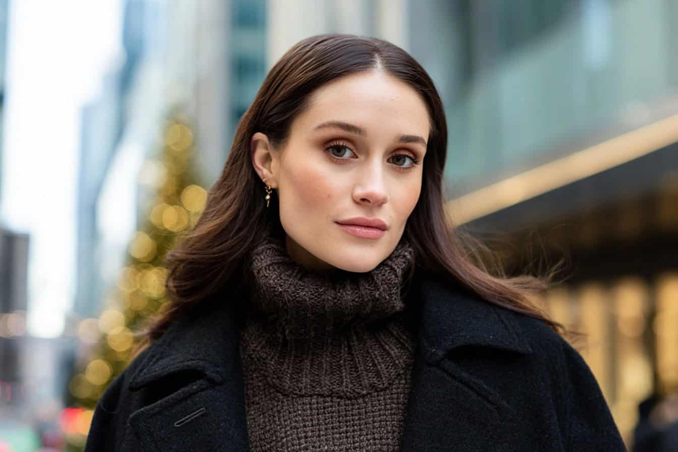 Woman in a brown turtleneck sweater and black coat on a winter city stroll